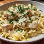 Close-up of creamy garlic parmesan chicken pasta topped with shredded cheese and fresh parsley.
