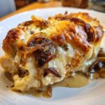 Close-up of a serving of french onion chicken topped with melted, browned cheese and caramelized onions.